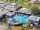 Aerial view of a community pool with lounge chairs and umbrellas surrounded by mature trees at 905 Barclay Ct, Venice, FL 34293