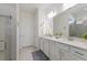 Bright bathroom features a double vanity, neutral countertops, white cabinetry and a walk-in shower at 10470 Spring Tide Way, Parrish, FL 34219
