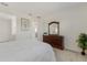 Bright bedroom with a brown wood dresser, neutral walls, white bedding and carpet at 10470 Spring Tide Way, Parrish, FL 34219
