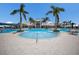 Large community pool with ample seating and palm trees surrounding with a view of the clubhouse at 10470 Spring Tide Way, Parrish, FL 34219