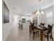 Dining area next to kitchen features a table set for four and modern light fixture at 10470 Spring Tide Way, Parrish, FL 34219