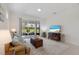 Cozy living room with comfortable seating, sliding glass doors to the patio, and a view of the backyard at 10470 Spring Tide Way, Parrish, FL 34219