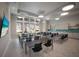 Well-lit meeting room with modern lighting, large windows, and functional tables and chairs at 10470 Spring Tide Way, Parrish, FL 34219