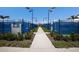 Pathway between pickleball courts featuring manicured landscaping and well-maintained playing surfaces at 10470 Spring Tide Way, Parrish, FL 34219