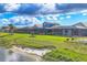 Backyard view of the house with covered patio, green lawn, and lake in a beautiful new construction neighborhood at 1092 Waterline Ct, Sarasota, FL 34240