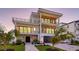 Contemporary three-story home featuring balconies, stone accents, and a well-manicured lawn at 1210 Gulf Blvd, Englewood, FL 34223
