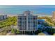 Luxury high-rise condo building with beautiful ocean views, lush landscaping, and a swimming pool at 1211 Gulf Of Mexico Dr # 701, Longboat Key, FL 34228