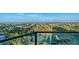 Balcony view overlooking tennis courts, lush landscaping, and the bay in the distance at 1211 Gulf Of Mexico Dr # 701, Longboat Key, FL 34228
