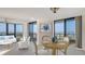 Bright dining area with a round wood table, chairs, and sliding glass doors to a balcony at 1211 Gulf Of Mexico Dr # 701, Longboat Key, FL 34228