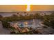 Beautiful sunrise view from above of a beachfront pool with palm trees and lounge chairs near the ocean at 1211 Gulf Of Mexico Dr # 701, Longboat Key, FL 34228