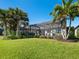 Expansive backyard with a pool, screened enclosure, palm trees, and well-maintained lawn at 12325 Marsh Pointe Rd, Sarasota, FL 34238