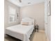 Cozy bedroom featuring a white bed, side table, and natural light from the window at 12325 Marsh Pointe Rd, Sarasota, FL 34238