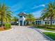 Community clubhouse featuring a circular driveway, tropical landscaping, and beautiful architecture at 12325 Marsh Pointe Rd, Sarasota, FL 34238