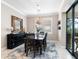 Elegant dining area with a wooden table, sideboard, modern chandelier, and access to the outdoor space at 12325 Marsh Pointe Rd, Sarasota, FL 34238