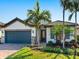 Charming single-story home with a brick driveway, attached garage, and well-maintained landscaping, including tropical palm trees at 12325 Marsh Pointe Rd, Sarasota, FL 34238