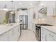 Stylish kitchen with white cabinets, granite countertops, stainless steel appliances, and a breakfast bar with seating at 12325 Marsh Pointe Rd, Sarasota, FL 34238