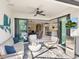 Covered lanai with comfortable seating, an outdoor TV, and views of the open-concept living area at 12325 Marsh Pointe Rd, Sarasota, FL 34238