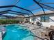 Backyard pool and patio area with grill, lush greenery, and screened enclosure at 12325 Marsh Pointe Rd, Sarasota, FL 34238