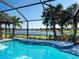 Inviting pool overlooking a scenic lake, surrounded by palm trees and lush landscaping at 12325 Marsh Pointe Rd, Sarasota, FL 34238