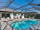 Backyard pool with a screened enclosure, patio furniture, and views of the house at 12325 Marsh Pointe Rd, Sarasota, FL 34238