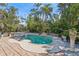 Beautifully landscaped pool area surrounded by lush tropical foliage and brick pavers at 1311 Tudor Rd, Englewood, FL 34224