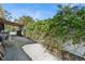 Side yard featuring lush flowering vines and a gravel path at 1311 Tudor Rd, Englewood, FL 34224