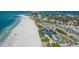 Scenic coastal view with a sandy beach, blue swimming pool, and beachfront properties at 132 Harrison Dr, Sarasota, FL 34236