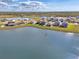 Beautiful aerial view of lakeside homes with well-maintained lawns under a partly cloudy blue sky at 13528 Sunset Sapphire Ct, Parrish, FL 34219
