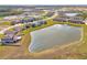 Aerial view showcases homes in the community around a serene lake under sunny skies at 13528 Sunset Sapphire Ct, Parrish, FL 34219