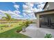 Well-maintained yard with view of screened lanai, manicured landscaping, and serene lake backdrop at 13528 Sunset Sapphire Ct, Parrish, FL 34219