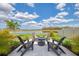 Outdoor seating area with a fire pit and chairs surrounded by lush landscaping and a scenic lake view at 13528 Sunset Sapphire Ct, Parrish, FL 34219