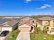 Beautiful two-story home with a well-manicured lawn, lush landscaping, and a vibrant red front door at 13528 Sunset Sapphire Ct, Parrish, FL 34219