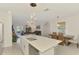 Bright open floorplan view of the kitchen island, the dining area, and the living room in the background at 13528 Sunset Sapphire Ct, Parrish, FL 34219