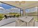 Screened patio with comfortable seating, outdoor dining area, and water view at 13528 Sunset Sapphire Ct, Parrish, FL 34219