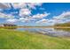 Scenic view of a serene pond surrounded by lush greenery and a clear blue sky at 13528 Sunset Sapphire Ct, Parrish, FL 34219