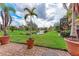 Backyard brick patio showcases beautiful landscaping and tranquil lake views at 1522 3Rd Street E Cir, Palmetto, FL 34221