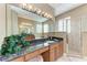 Bathroom with large mirror, wooden cabinets, granite counters, and glass shower enclosure at 1522 3Rd Street E Cir, Palmetto, FL 34221