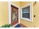 Inviting entryway features a glass door and a window with white trim, set against a textured yellow wall at 1522 3Rd Street E Cir, Palmetto, FL 34221