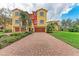 Charming townhome featuring colorful facade, brick driveway and manicured landscaping at 1522 3Rd Street E Cir, Palmetto, FL 34221