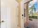 Open foyer area with a view through the glass front door, showcasing the brick-paved pathway and landscaping at 1522 3Rd Street E Cir, Palmetto, FL 34221