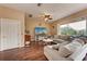 Bright living room with hardwood floors, neutral-toned furniture, ceiling fan, and a view from the sliding glass door at 1522 3Rd Street E Cir, Palmetto, FL 34221