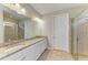 Well-lit bathroom showcasing a granite countertop, dual sinks, and a glass door shower at 167 Maraviya Blvd, Nokomis, FL 34275