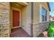 Inviting front entrance featuring a red door, stone accents, and a charming brick walkway at 167 Maraviya Blvd, Nokomis, FL 34275