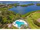 Scenic aerial view of a pool and waterfront, surrounded by palm trees and walking paths at 1680 Brookhouse Cir # 110, Sarasota, FL 34231