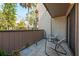 View of the exterior balcony featuring chairs, a small table, and a wooded view at 1680 Brookhouse Cir # 110, Sarasota, FL 34231