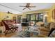 Bright living room featuring a ceiling fan, glass coffee table, and sliding glass doors to the outdoor area at 1680 Brookhouse Cir # 110, Sarasota, FL 34231