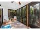Enclosed sunroom with beautiful views of the surrounding greenery and comfortable seating at 1680 Brookhouse Cir # 110, Sarasota, FL 34231
