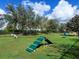 Community dog park complete with agility equipment, lush green grass, and mature trees for shading at 17217 Verona Pl, Lakewood Ranch, FL 34202