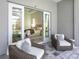 Outdoor patio area with wicker chairs offering a view into the main bedroom with French doors at 17217 Verona Pl, Lakewood Ranch, FL 34202