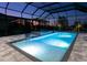 Nighttime view of screened pool area featuring a hot tub and outdoor lighting at 17217 Verona Pl, Lakewood Ranch, FL 34202